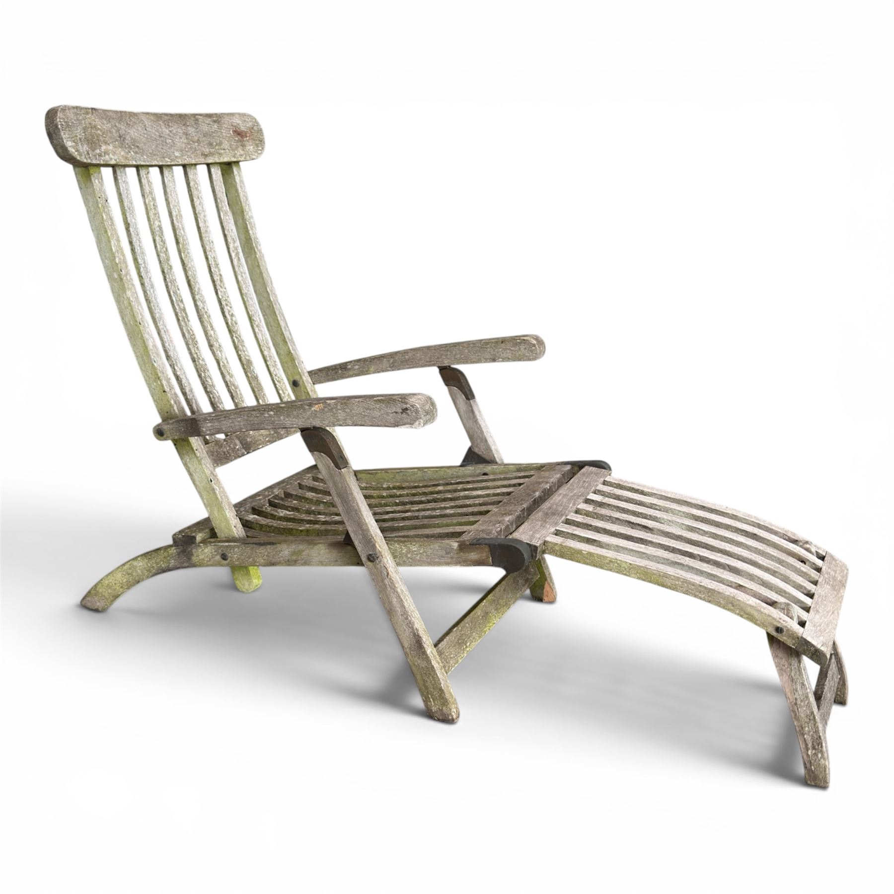Pair of teak reclining garden steamer armchairs, each with an adjustable slatted back, curved slatted seat and footstool