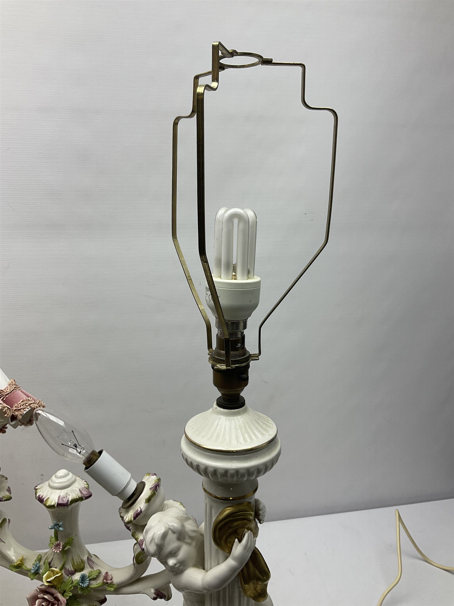 Jaffe Rose figural ceramic table lamp, modelled as two putti climbing a column with gilded cloth, together with a Capodimonte floral two light table lamp and a collection of lamp shades