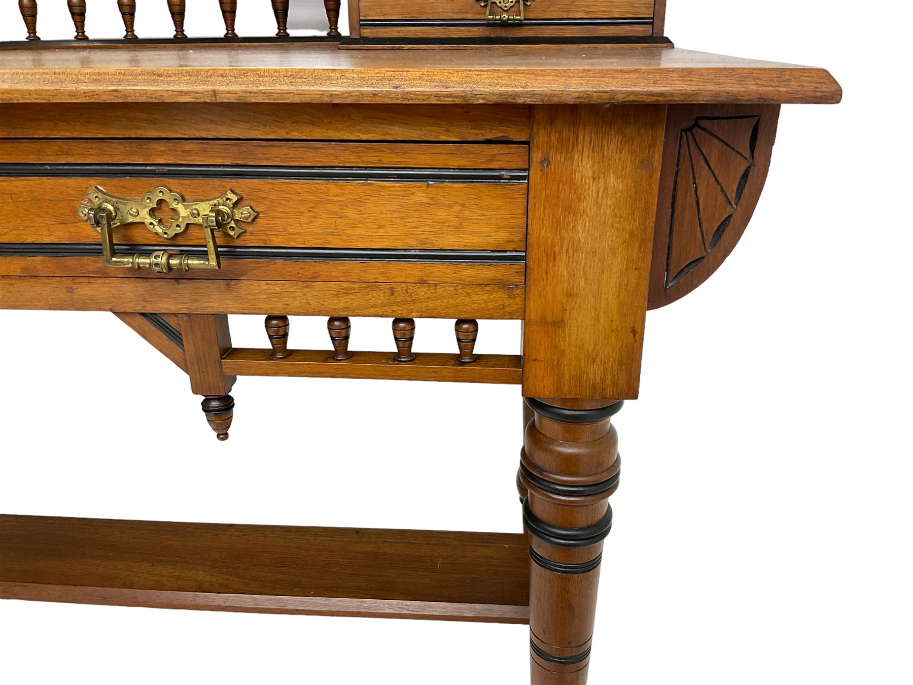 Late Victorian Aesthetic Movement walnut and inlaid ebony dressing table, swing mirror back with shell carving and spindle support rail, fitted with two trinket drawers and single frieze drawer, raised on ring turned supports with castors