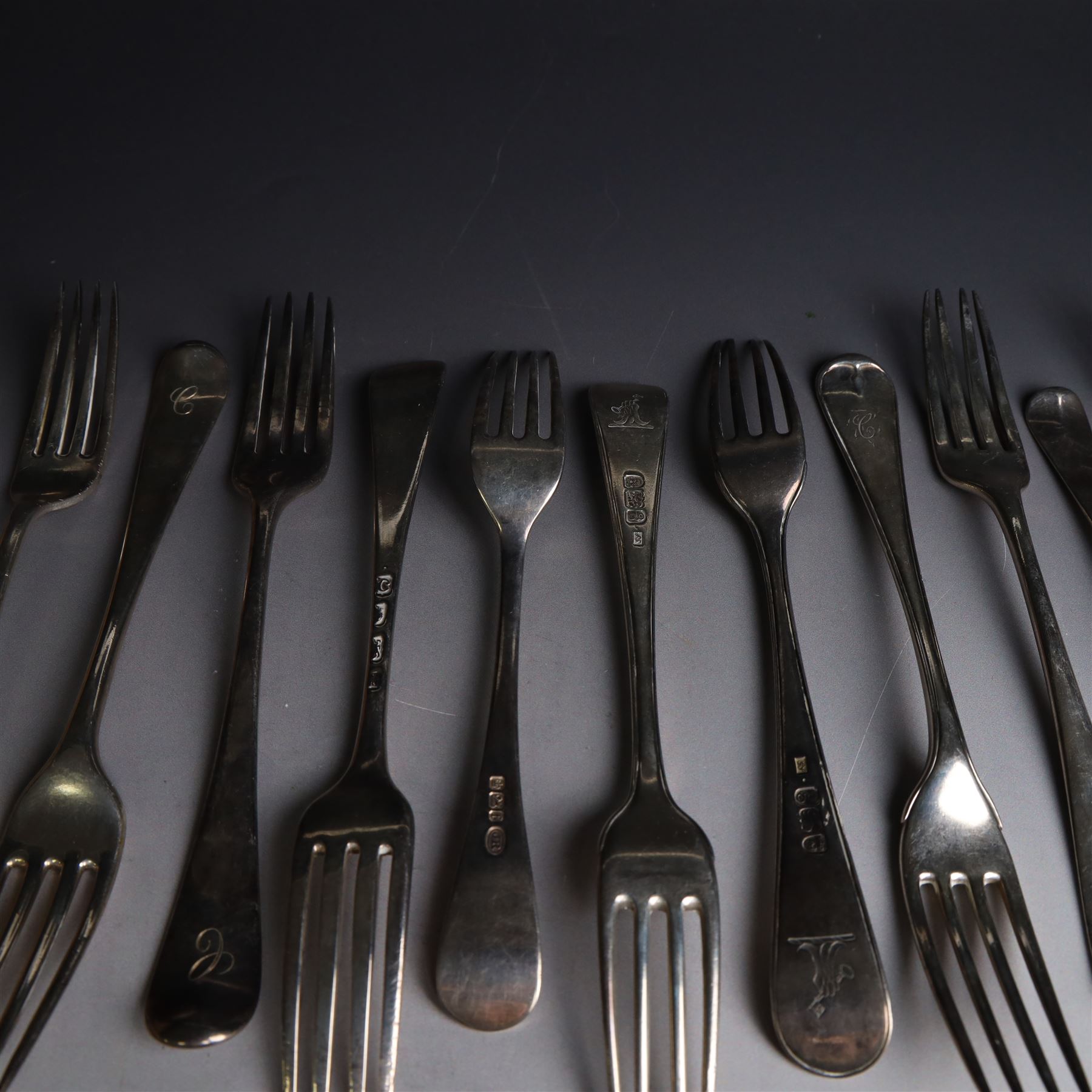 Seventeen Georgian and later silver Hanoverian pattern table and dessert forks, most with engraved initials to terminal and crests verso, including pair of table forks hallmarked William Sumner & Richard Crossley, London 1778