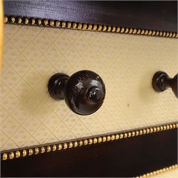 Empire design ebonised and parcel gilt hall stand, projecting moulded cornice with bead and reel border, upper rail fitted with three turned hat and coat pegs, central cream upholstered panel within beaded slip, flanked by scrolled uprights with gilt foliate and anthemion mounts, lower acanthus leaf apron, on paw feet