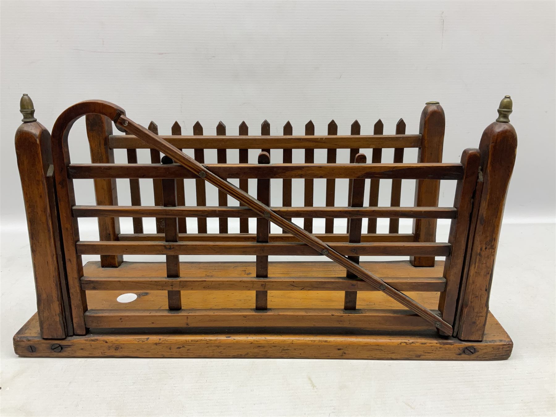 Early 20th century novelty letter rack modelled as a gate and picket fence, with brass post finials, on pine base, L43cm