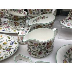 Minton Haddon Hall pattern tea and dinner wares, including basket dish, two covered tureens, six dinner plates, eight dessert plates, twelve tea plates, six soup bowls, six cereal bowls, teapot, coffee pot, milk jug, covered sucrier twelve tea cups and saucers, six mugs, footed bon bon dish, pair of candlestick holders, cake knife and slice etc (81)