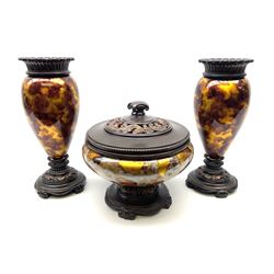 A three piece bronzed composite garniture, comprising two baluster vases and pot and cover, with marbled tortoiseshell effect decoration, vases H37cm, pot and cover overall H26.5cm. 