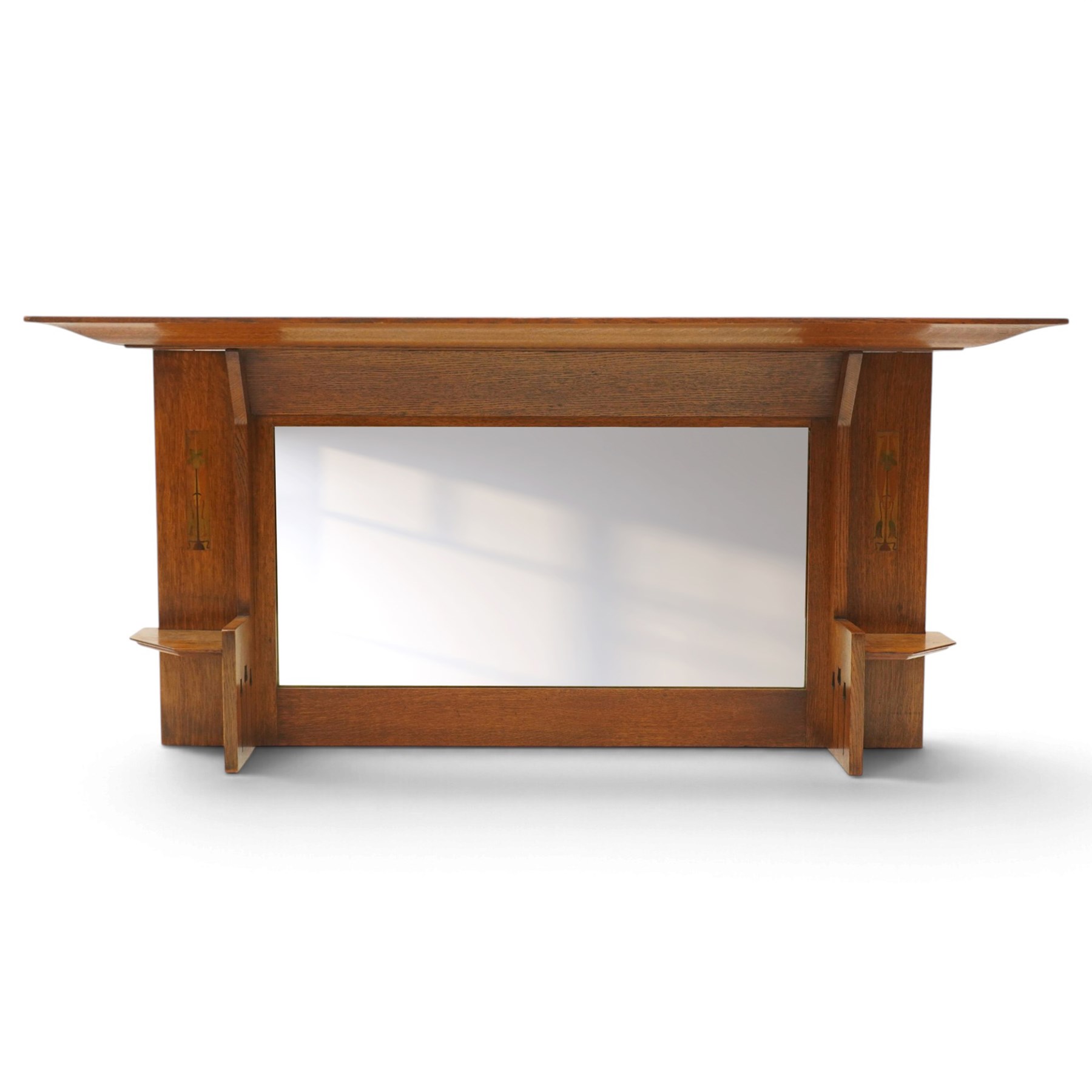 Manner of Liberty & Co, - Arts & Crafts inlaid oak overmantel mirror, the deep-projecting cornice over a rectangular plate, flanked by Art Nouveau marquetry panels of stylised tulip and foliate motifs, over a canted shelf and tulip-pierced upright