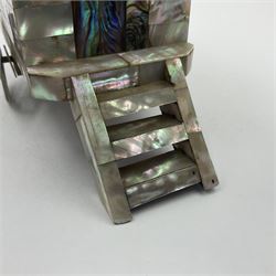 19th century French souvenir jewellery casket in the form of a bathing machine, having mother of pearl panelled tiled effect body, hinged roof/cover revealing a blue silk fitted interior with cushioned base, two silvered metal wheels, abalone shell door and mother of pearl steps, inscribed 'Berck Plage' in blue, H12cm, W13cm 