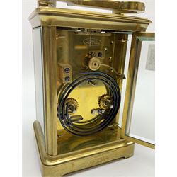 Early to mid 20th century French brass and bevelled glass cased carriage clock, the shaped loop handle over oval glass panel, white enamel Roman dial, twin train driven eight day movement striking on coil, with button push repeater, the movement back plate stamped for 'R & Co.'
