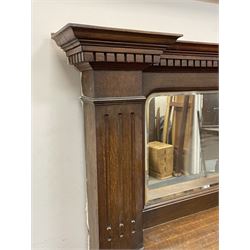 Late 19th/early 20th century fireplace, oak surround with projecting dentil cornice over bevelled mirror and shelf, with copper inset decorated with Heraldic knot motifs and rivets, together with various fire accessories 