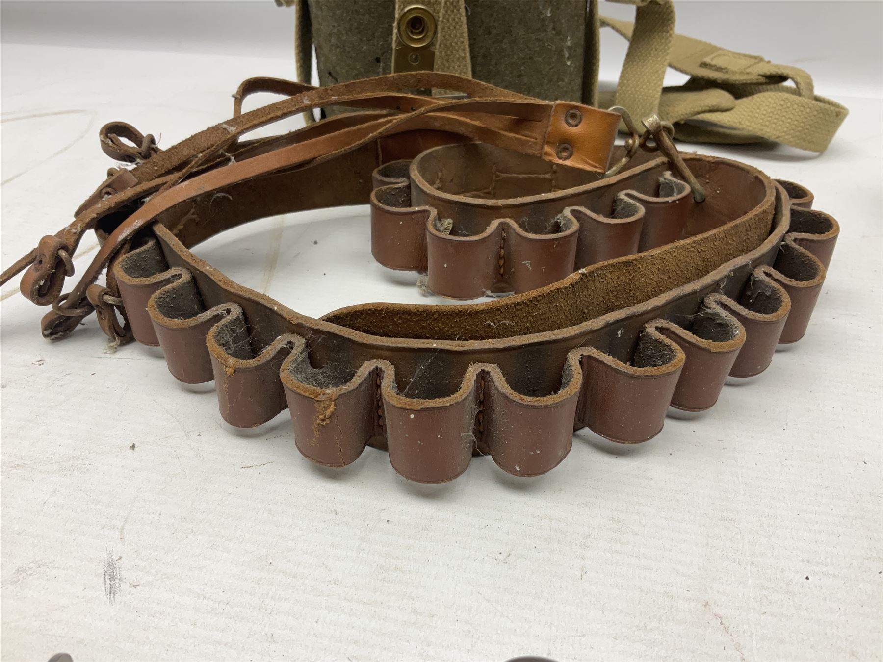 Mundial Brazil bowie knife, the 15.5cm steel blade inscribed 'Sheriff Knife', with banded and aluminium hilt; in leather sheath L29cm overall; British Army felt covered metal water bottle with webbing strap; leather 12-bore cartridge belt; and small pair of non-military binoculars in part case (4)