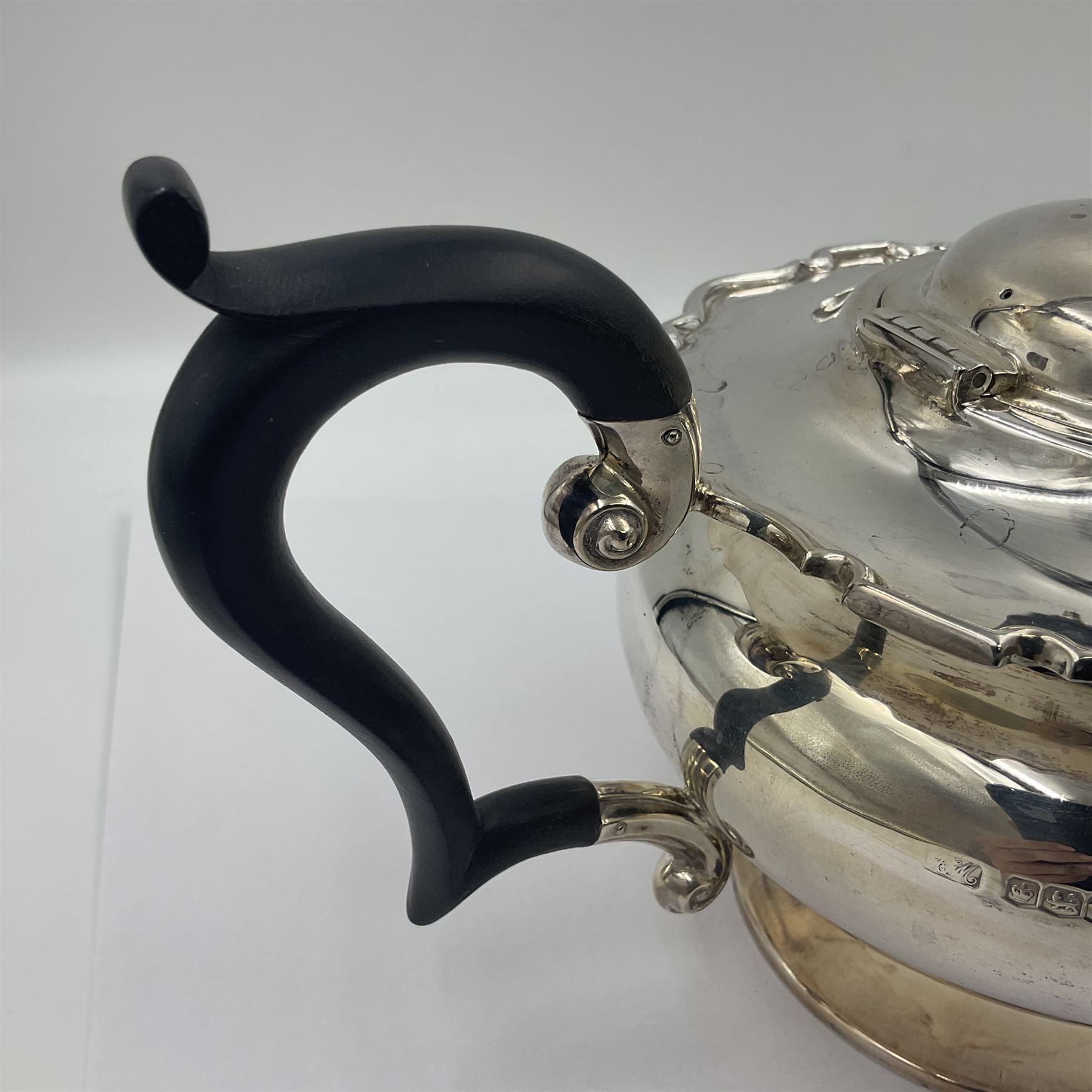 1920s five-piece silver tea service, comprising teapot, coffee pot, hot water pot, twin handled open sucrier and milk jug, each of squat circular form with shaped rim, the teapot, coffee pot and hot water pot each with ebonised handle and finial, the sucrier and milk jug with acanthus capped scroll handles, all upon circular foot, hallmarked R F Mosley & Co, Sheffield 1926 & 1927, tallest H24cm