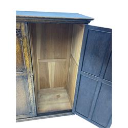 Early 20th century oak triple wardrobe, three panelled doors with geometric mouldings and fretwork spandrels, the interior fitted with slides and hanging rail
