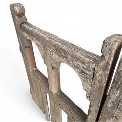Pair of 19th century weathered wooden ecclesiastical church gates, the cresting rail over four pierced arches with slatted lower section, fitted with heavy cast iron hinges, latch and fittings