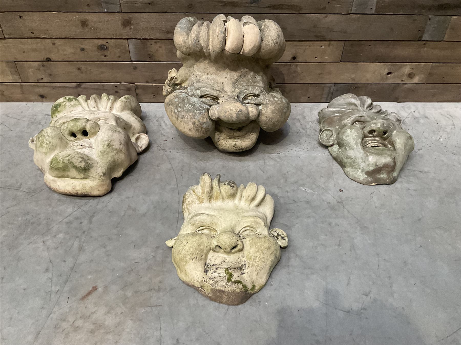 Four grotesque garden wall masks