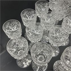 Early 20th century cut glass decanter, the body decorated with hobnail, star and fan cut decoration, with faceted neck and matching stopper, together with a collection of matching glasses, all with similar cut decoration, including sherry glasses, champagne coupes and wine glasses (43), decanter H34cm