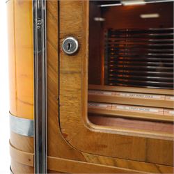 Rudolf Wurlitzer Company - Model 616 'Simplex' 1937 jukebox, figured walnut veneered cabinet with illuminated red and amber side panels enclosed by chromed uprights, glazed upper record compartment, cast Art Deco speaker grille, coin-operated push-button selection panel with circular title index, raised on a moulded base