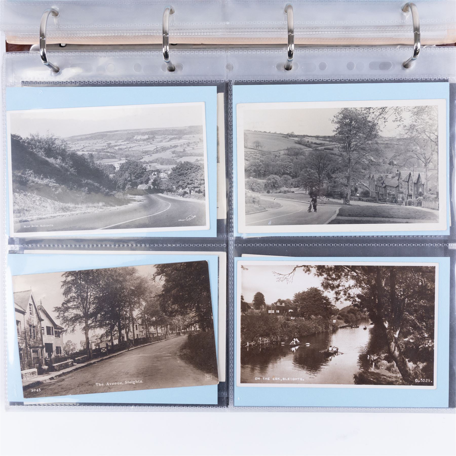 Four-hundred and twelve early 20th century Whitby District view real photographic postcards, including a selection from the Whitby Coast (176), starting at Staithes and Runswick Bay down to Robin Hoods Bay and a selection from the Valley of the River Esk (236), including Ruswarp, Rig Mill, Sneaton, Sleights, Grosmont, Egton, Glaisdale, Danby, Castleton and Goathland, all housed within two postcard albums