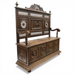 19th century European heavily carved oak hall settle, the impressive high-back with a pierced and carved acanthus pediment, over foliate and rosette carved back rails, flanking a central panel depicting a gentleman on horseback drinking, the hinged box seat over a quadruple panelled front with relief carved busts, lower moulded and carved edge on compressed bun feet