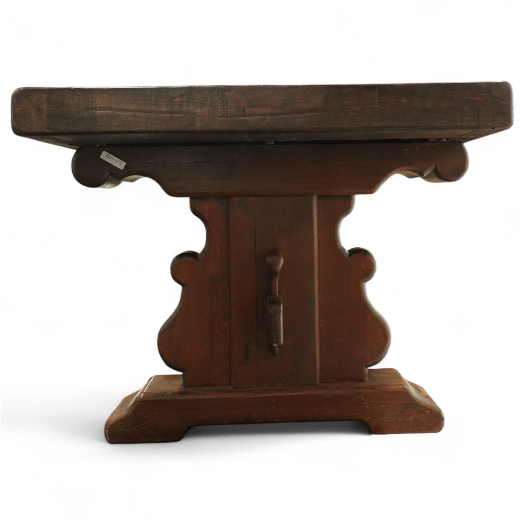Early 20th century French oak refectory table, the thick rectangular top with cleated ends above shaped lyre-form trestle supports, united by a central stretcher, on broad scrolled feet, displaying well-figured quarter sawn grain across the top