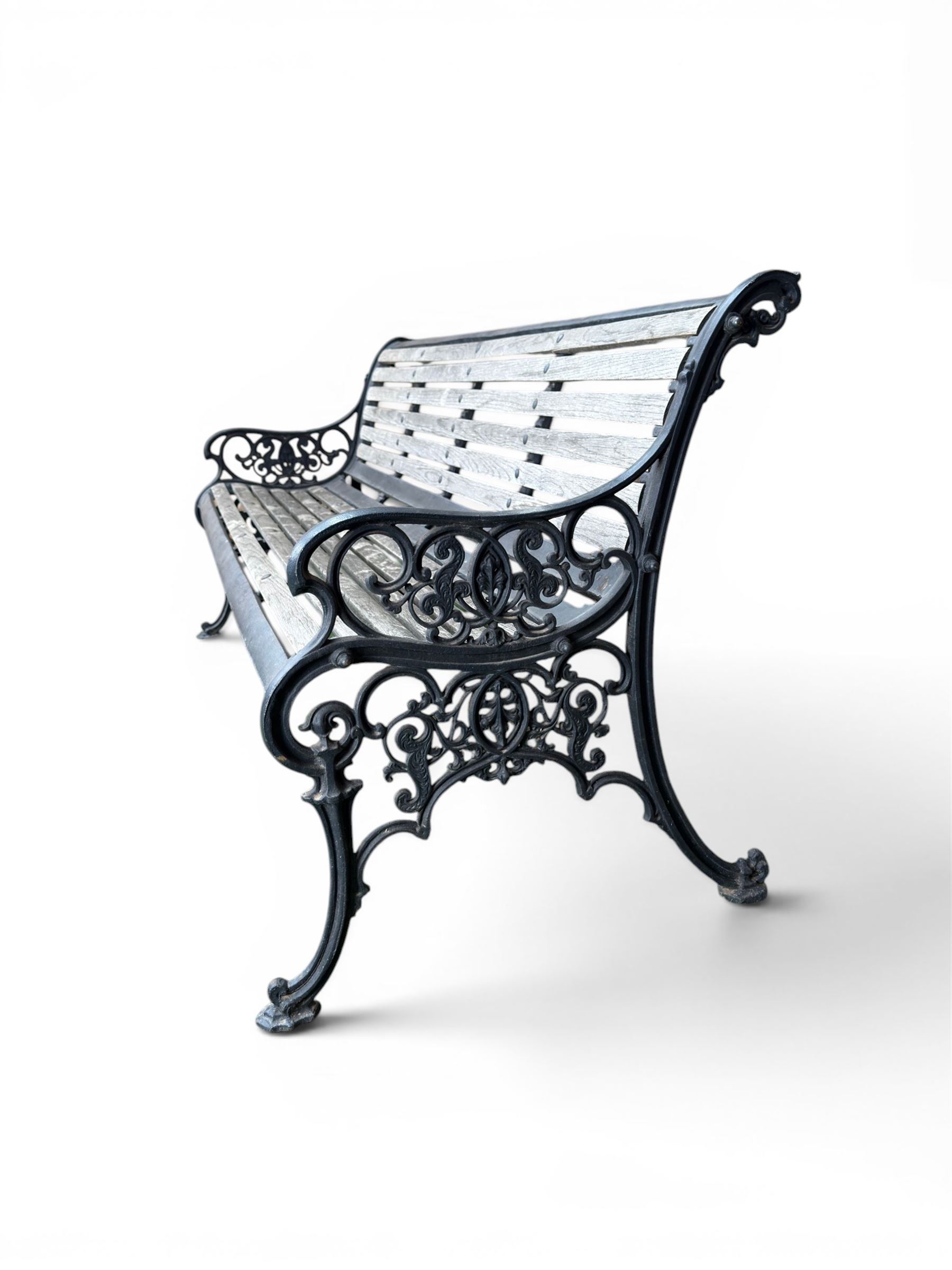 Victorian Andrew McLaren pattern cast iron bench, the ornate ends with detailed scrollwork, joined together with a cast iron seat and backrest frame supporting gently weathered oak slats, Victorian diamond stamp mark