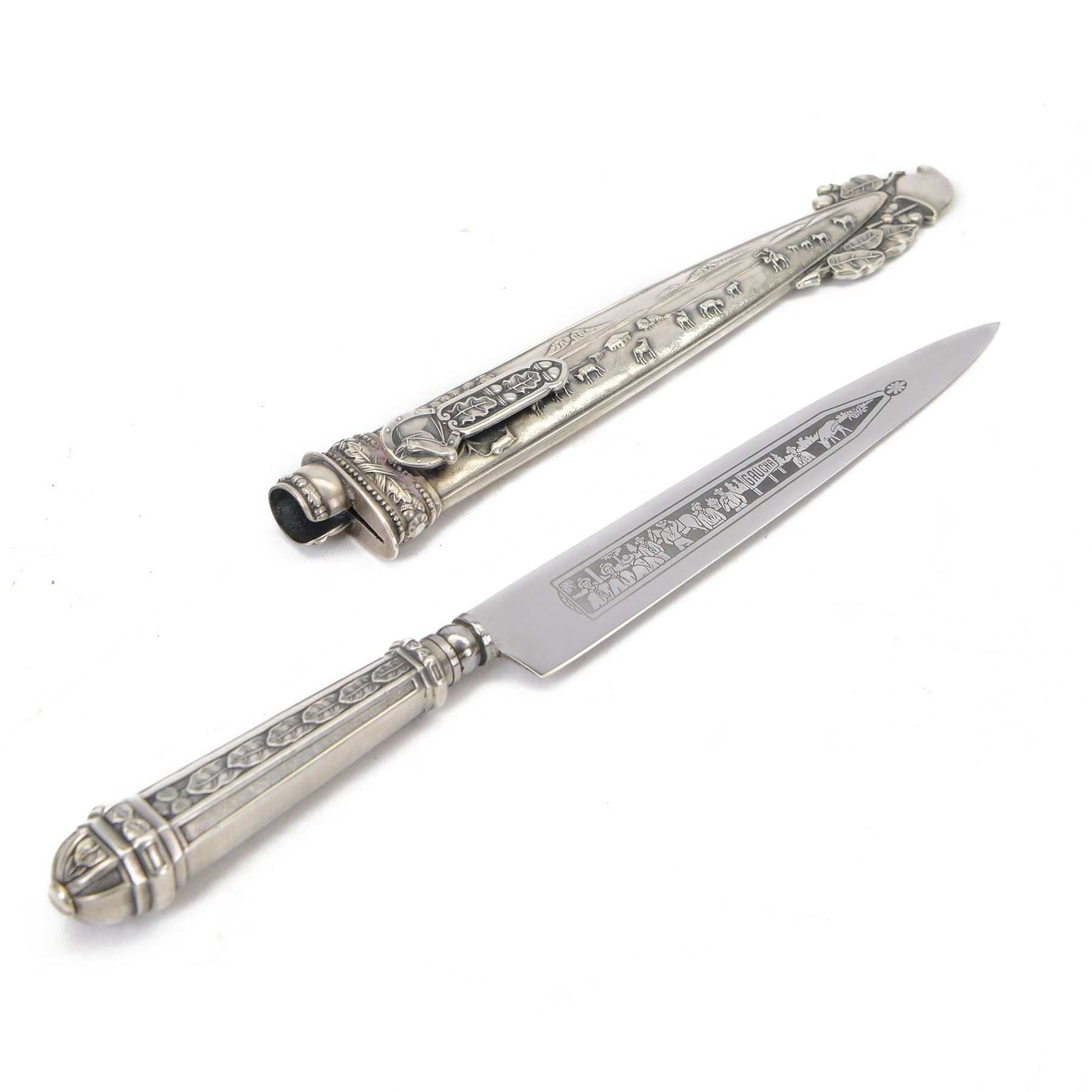 Argentinian Gaucho dagger and scabbard, decorated with oak leaves and cattle scenes with Inox blade, overall L29cm, blade 17cm
