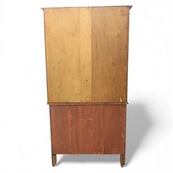 20th century wooden bookcase cabinet, fitted with a pair of leaded glass panel doors opening to adjustable shelves, the base top and front veneered in richly figured walnut, contrasted with solid oak panelled sides and shaped lower frieze, terminating in castors