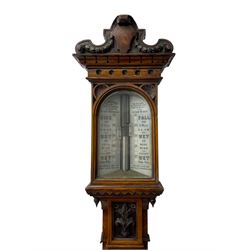 J Hicks - Hatton Garden London, - late 19th century carved oak cased Fitzroy barometer in a richly carved case with a carved crested pediment and square cistern cover, inverted opaline register reflecting FitzRoy's predictions and a scale from 27 to 31 inches of barometric pressure, with a thick bore cistern tube and adjustable rack and pinion twin vernier, fitted with a glazed snail bulb mercury thermometer recording the air temperature in both Fahrenheit and Celsius. Mercury clean and present.
James Joseph Hicks was born in Ireland, however, early in his life he moved to London where he was apprenticed to the instrument maker Louis P Casella. In 1860 he went into business in his own right as a scientific instrument maker at 8 Hatton Gardens. In 1864 he was granted membership to the British Meteorological Society and exhibited instruments at the Royal Society Exhibitions between 1876 and 1913. Hicks was one of London's most prolific and eminent barometer makers. 