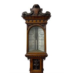 J Hicks - Hatton Garden London, - late 19th century carved oak cased Fitzroy barometer in a richly carved case with a carved crested pediment and square cistern cover, inverted opaline register reflecting FitzRoy's predictions and a scale from 27 to 31 inches of barometric pressure, with a thick bore cistern tube and adjustable rack and pinion twin vernier, fitted with a glazed snail bulb mercury thermometer recording the air temperature in both Fahrenheit and Celsius. Mercury clean and present.
James Joseph Hicks was born in Ireland, however, early in his life he moved to London where he was apprenticed to the instrument maker Louis P Casella. In 1860 he went into business in his own right as a scientific instrument maker at 8 Hatton Gardens. In 1864 he was granted membership to the British Meteorological Society and exhibited instruments at the Royal Society Exhibitions between 1876 and 1913. Hicks was one of London's most prolific and eminent barometer makers. 