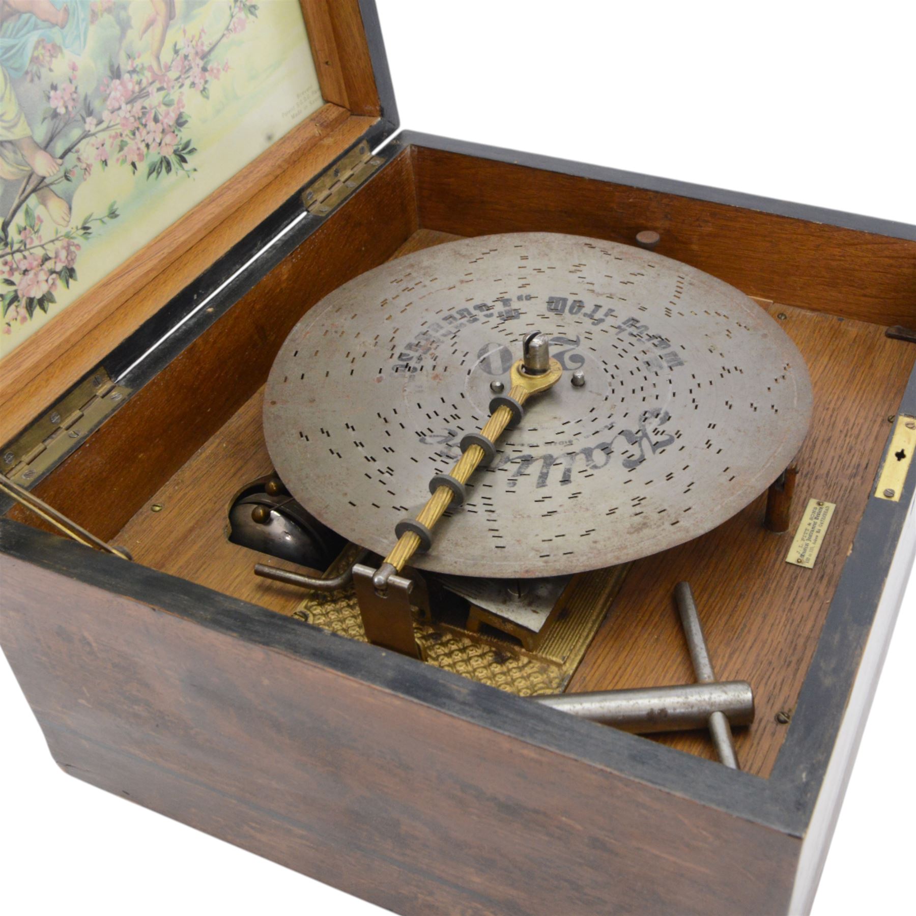 German-late 19th century Polyphon, in a mahogany finished case with a decorative inner Kalliope trade decal, with a 48 tooth steel comb on a gilt cast base and central driving spindle, with six bells and hammers and one 9-1/8” disc. Serial No 113007. With Key.