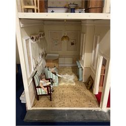 Kit-built wooden dolls house, possibly by Honeychurch, as a 19th century style double fronted two-storey residence; with stucco walls and flat roof with circular skylight and parapet with balusters; central door with fanlight, Corinthium columns and balcony over; simulated sash windows to three sides; hinged front facade opening to reveal a partially furnished interior with central hall, stairs and landing, two ground floor rooms and two first floor en suite bedrooms; wired for electric lighting W69cm H70cm D41cm