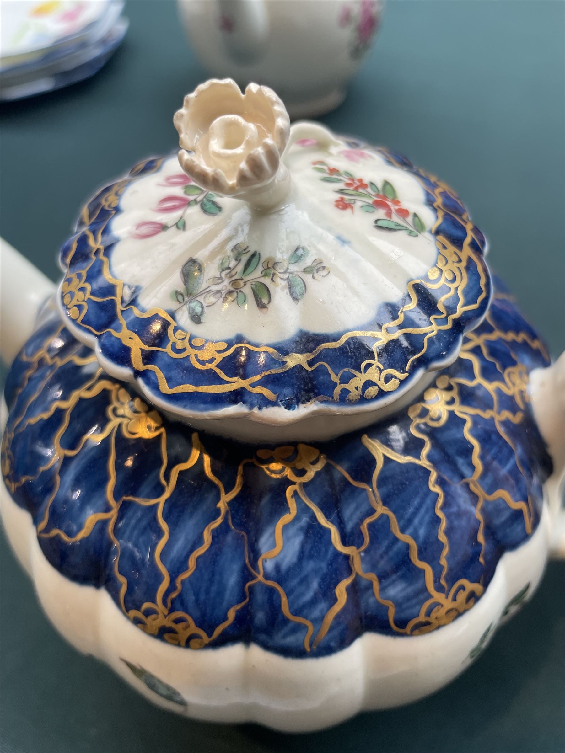 Liverpool Phillip Christian teapot and cover, c. 1775, the reeded body painted with floral sprays beneath a blue border with gilt decoration, the cover with flower-bud finial, H15.5cm; together with an 18th century Worcester teapot, with painted floral decoration (2)