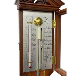 20th century - mercury cistern barometer in an 18th century style mahogany case with contrasting inlay and a broken pediment, round base with a turned cistern cover, fully exposed glass tube and silvered register within a glazed door, with a Fahrenheit spirit thermometer, engraved weather predictions and sliding vernier. Mercury clean and present.
