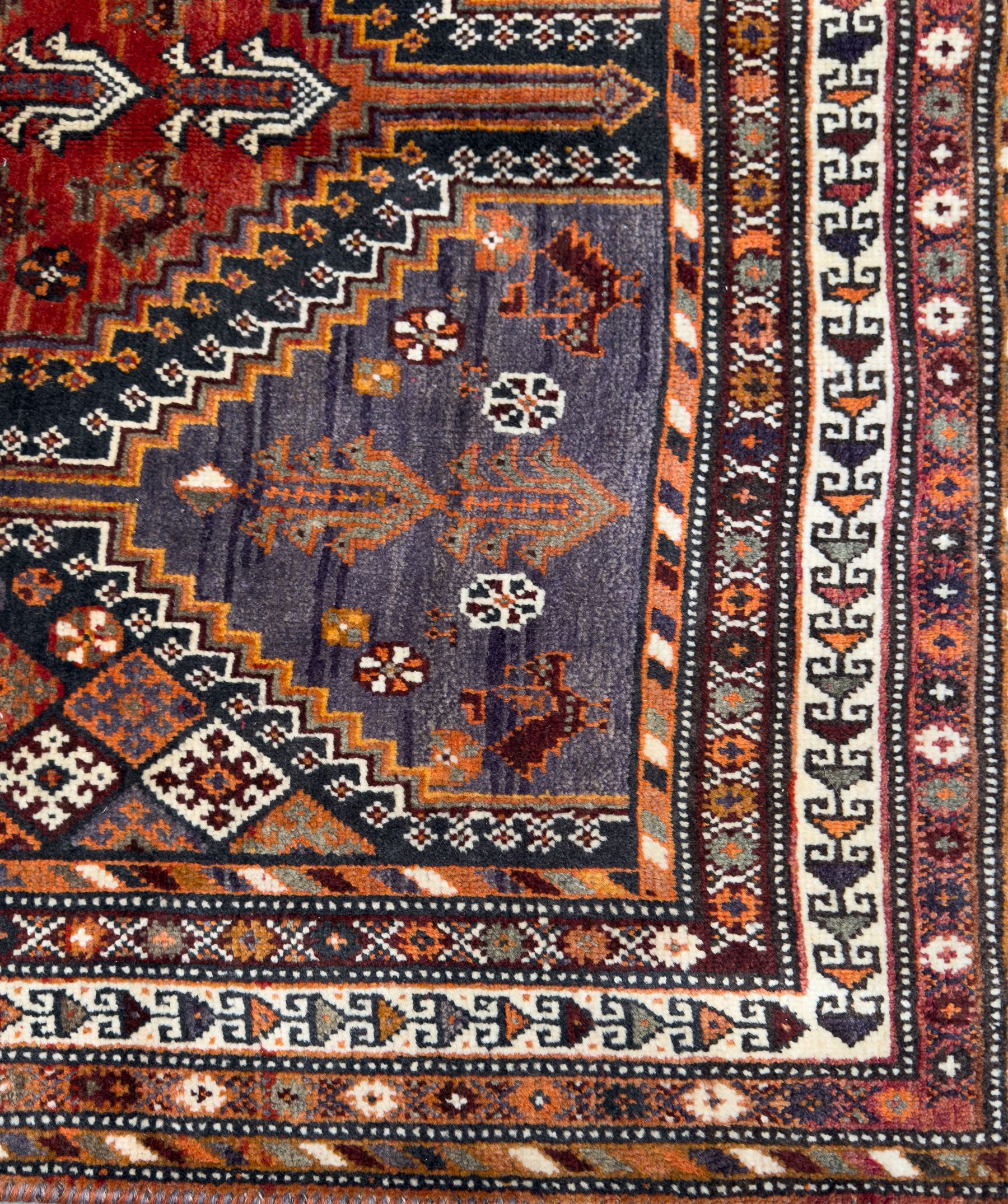 Southwestern Persian Qashqai hand-knotted carpet, the field with a lattice of hexagonal medallions in rust, indigo, and ochre, each containing stylised tree and floral motifs, flanked by lozenge panels with geometric designs, enclosed by multiple borders with rosettes and leaf motifs
