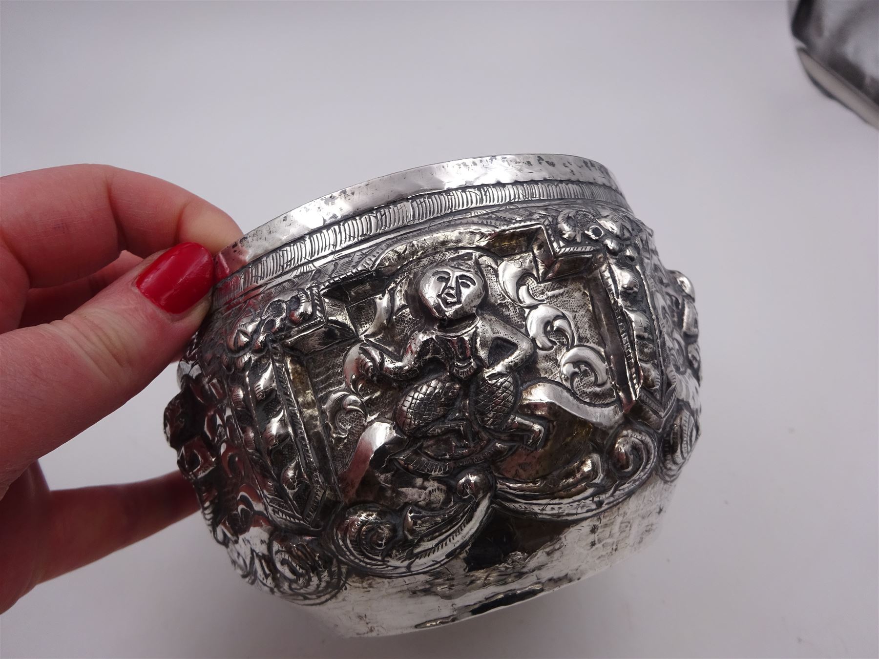 Burmese silver bowl, embossed with figural panels, C scrolls and floral decoration, H8.5cm