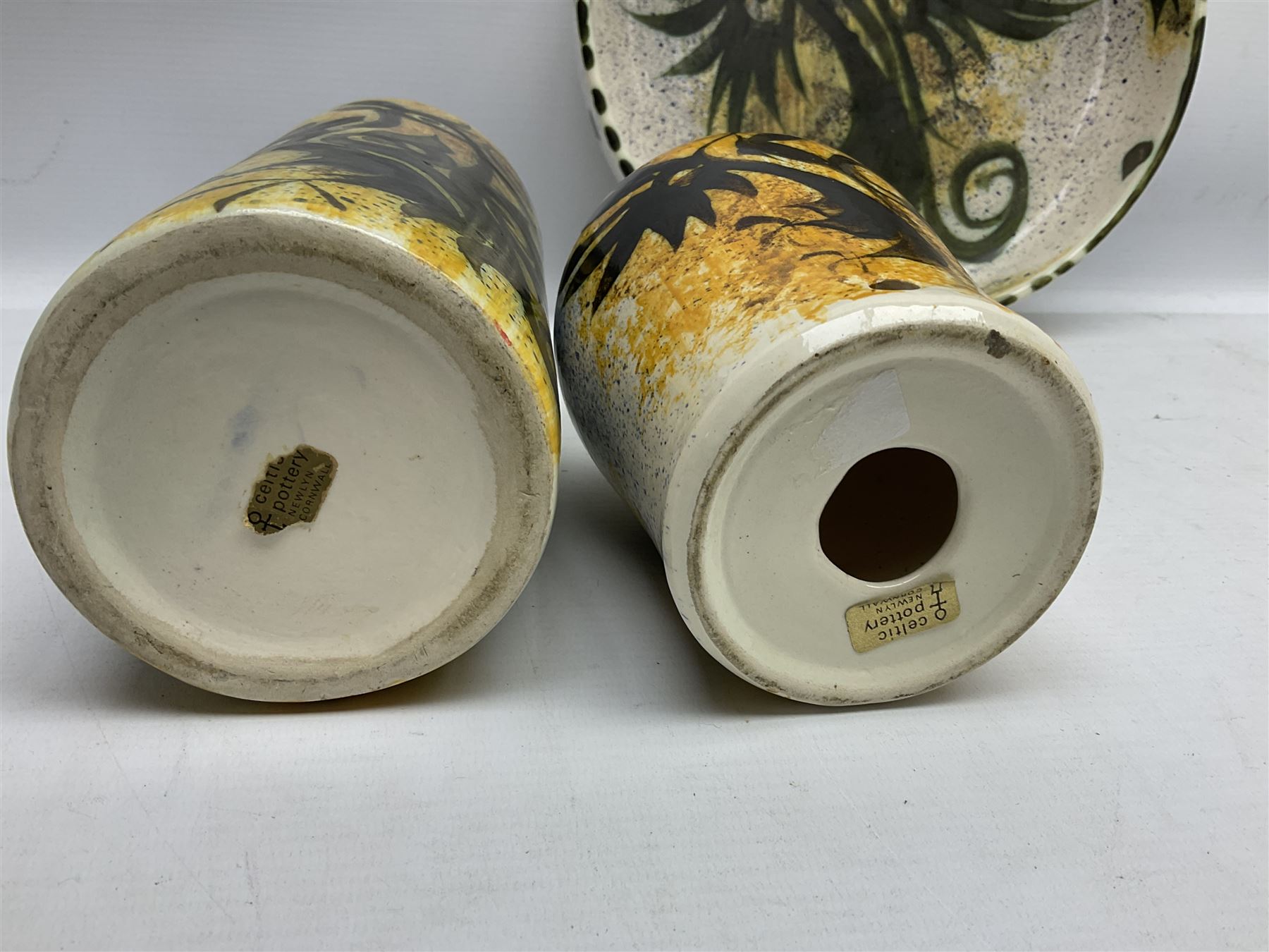 20th century Celtic Pottery, Newlyn, table lamp of tapering form, cylindrical vase and shallow bowl, all decorated with a dark stylised phoenix, modelled with wings outstretched upon sponged ochre, blue and cream ground, bowl D26cm