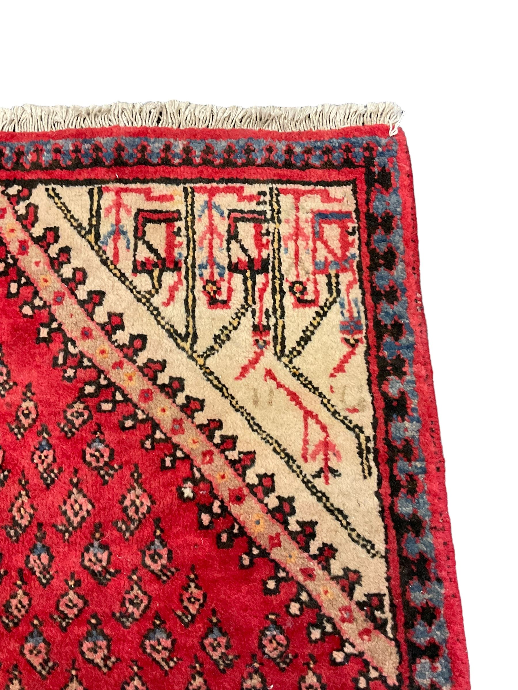 Small Persian red ground rug, lozenge medallion surrounded by small Boteh motifs