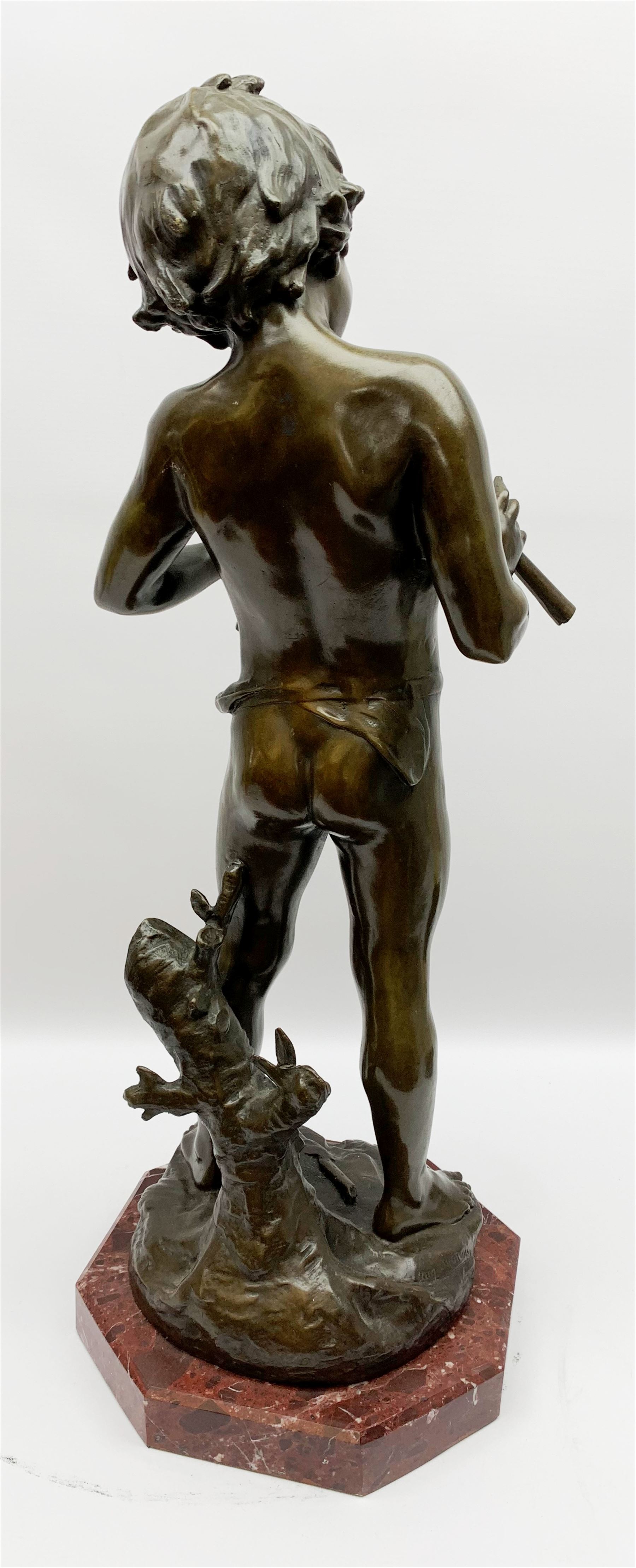 After Auguste Moreau (French 1834-1917): large bronze figure modelled as a young boy playing two pipes, standing upon a naturalistically modelled base detailed with tree stump and further pipe, signed Aug Moreau, upon octagonal red marble base, H72cm 