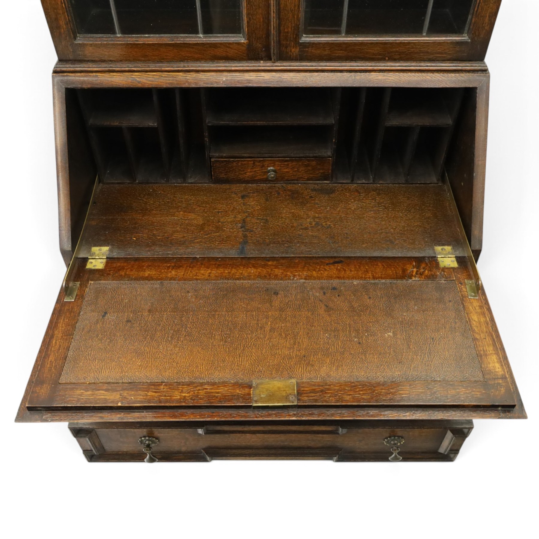 Early 20th century Jacobean Revival oak bureau-bookcase, astragal glazed doors enclosing two adjustable shelves, over geometric panelled fall-front enclosing fitted interior, over two drawers, raised on a spiral-turned base with barley-twist stretchers and compressed bun feet