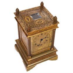 Early 20th century brass mantle clock, the face and case profusely engraved with floral scrolls, the sides inset with hunting scene panels, flanked by four Corinthian columns with acorn finials, striking the hours and halves on bell, H20.5cm W13cm