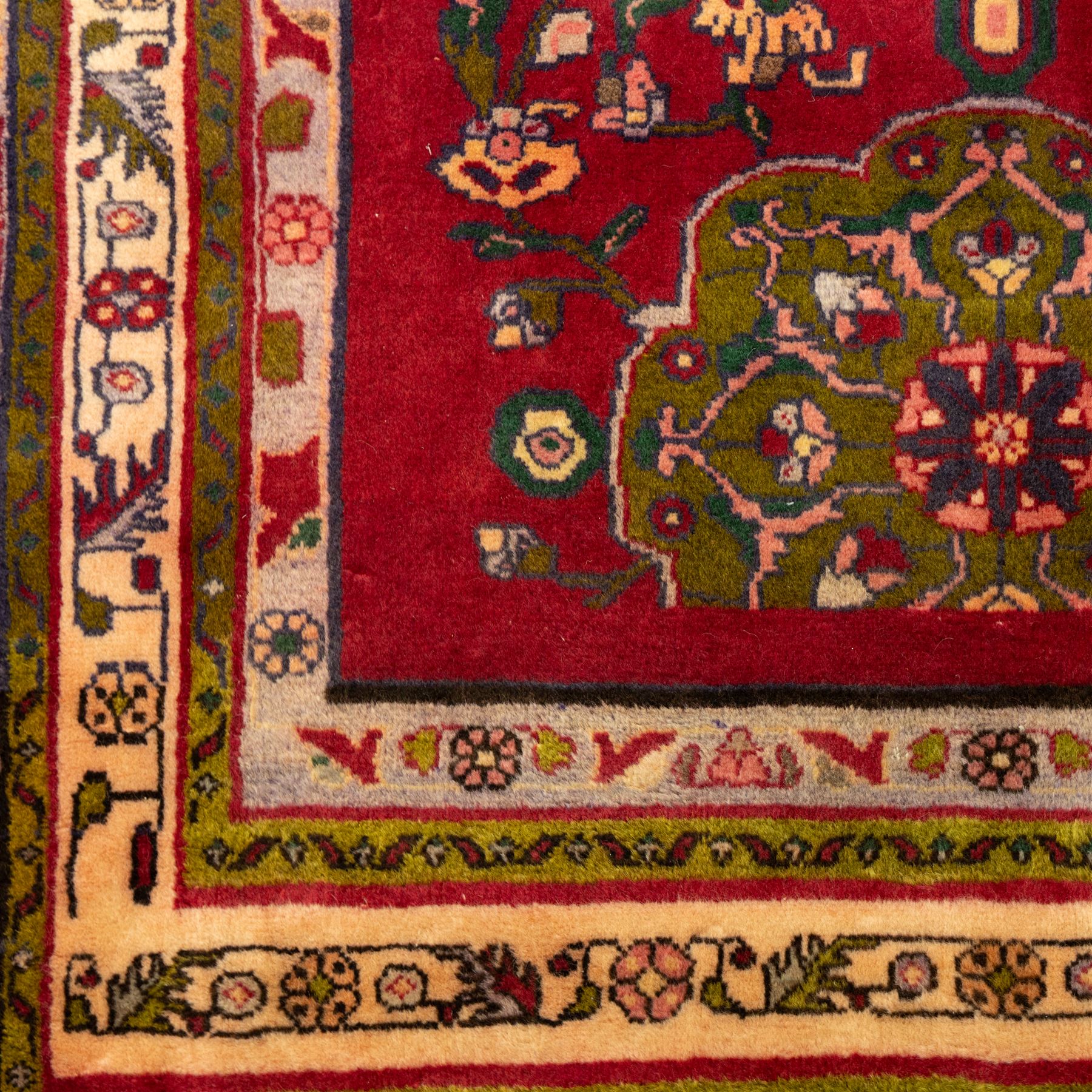 North West Persian Tariz hand-knotted runner, madder red field with a column of linked lozenge medallions in shades of indigo blue and pistachio green framed by stylized floral motifs within triple borders of rosettes and scrolling vines on an ivory ground, with cotton fringe ends