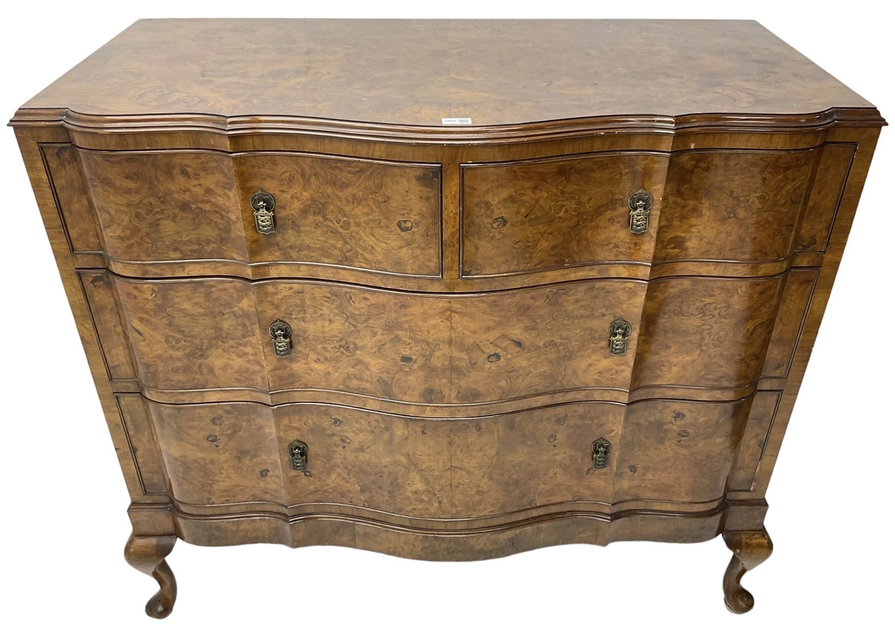 Early to mid-20th century figured walnut serpentine chest, moulded top over two short and two long cock-beaded drawers, fitted with drop handles in the form of shields with three recumbent lions, on cabriole feet