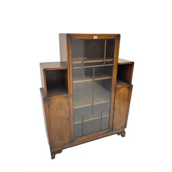 Early 20th century Art Deco walnut display cabinet, break-top with the central astragal glazed door enclosing four adjustable shelves, flanked by two pigeonholes over two burr cupboard doors concealing two shelves