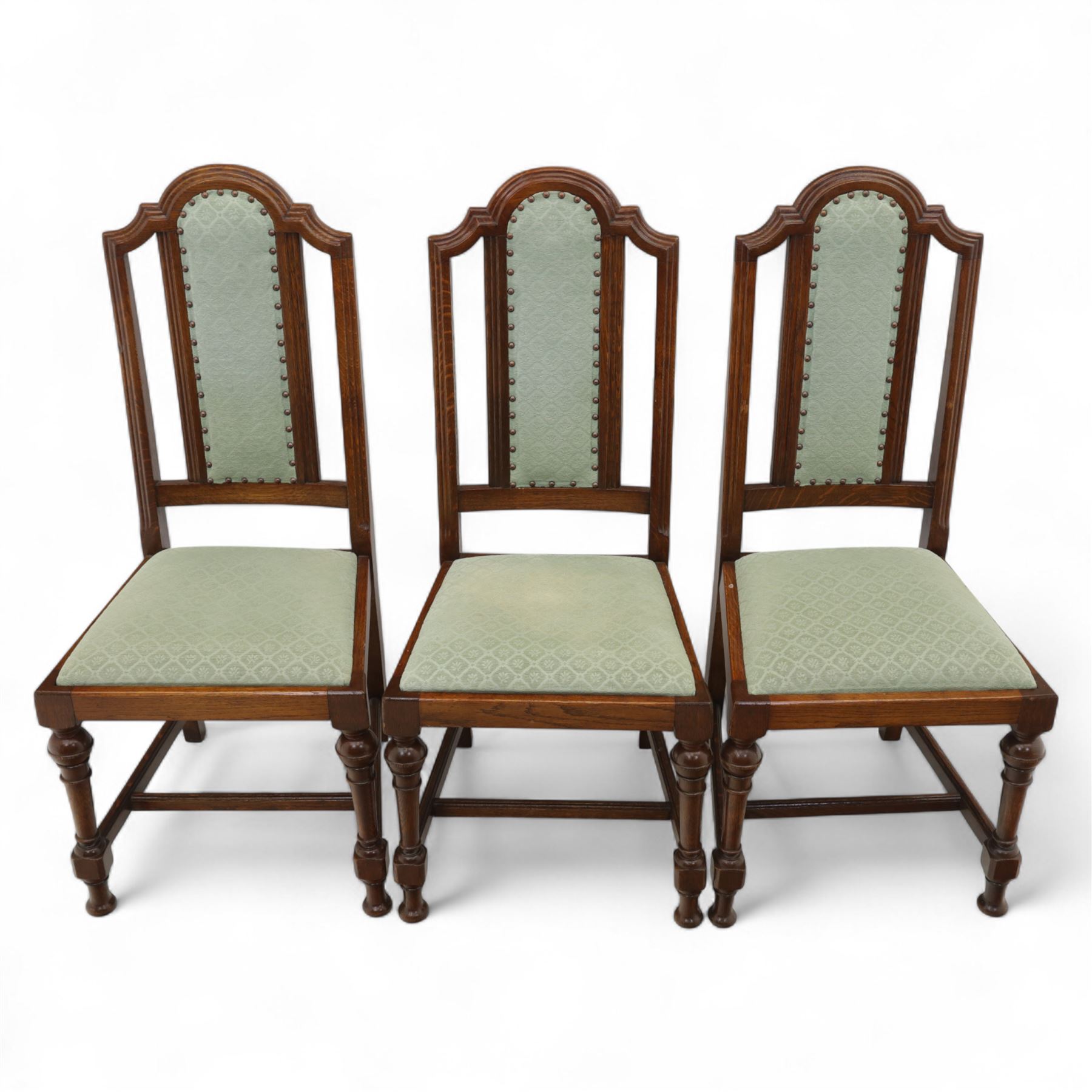 Victorian mahogany extending dining table, rectangular top with chamfered corners above a plain frieze raised on turned reeded legs with castors and two additional leaves, 197cm fully extended, and a set of six early 20th century oak upholstered chairs with drop-in seats, arched panelled back splat and close studded border on turned front legs joined by stretchers, 47x41x109cm 