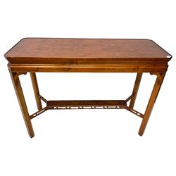 Wade - yew wood console table, rectangular top with canted corners and raised lipped edge, on chamfered square supports united by narrow under-tier