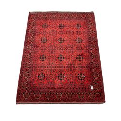 Afghan red ground rug, decorated all over with plant and flower head motifs, repeating border
