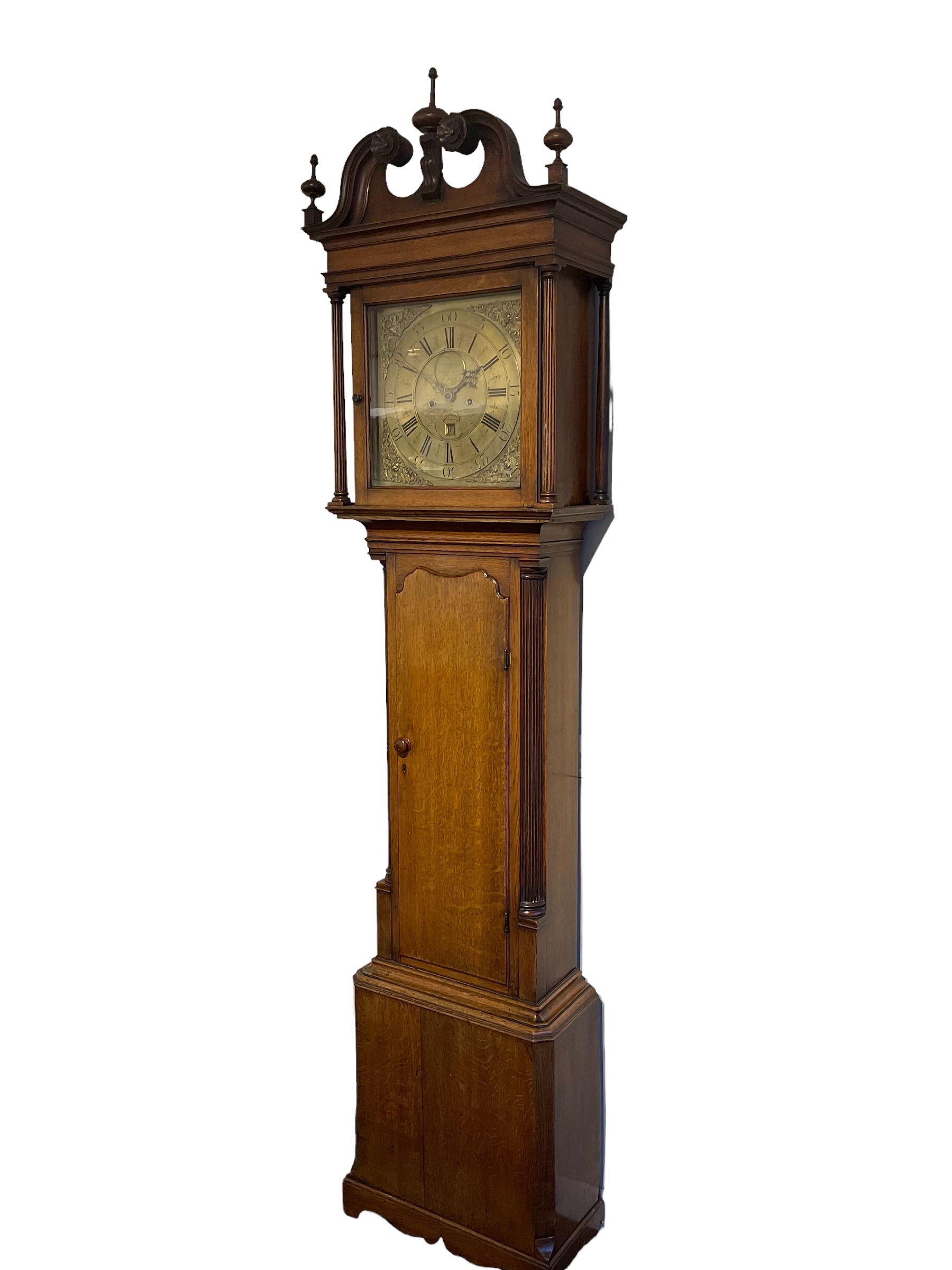 30-hour 18th century oak cased longcase clock by Jeremiah Standring of Bolton, (Lancs) c 1770, with a swan’s neck pediment on a flat top with a blind frieze beneath, square brass dial flanked by reeded pilasters and wooden capitals, long trunk door with a concave wavy top, trunk with reeded quarter columns on a rectangular plinth on a decorative skirting, dial with a formerly silvered chapter ring and engraved dial centre, with Roman numerals, five minute Arabic’s, square date aperture, circular boss engraved with the makers name, cast spandrels and “dummy” winding arbors, dial pinned directly to a rope driven countwheel striking movement, striking the hours on a bell. With weight and pendulum. 
30-hour clocks with “dummy” winding arbors are more commonly found on later 19th century painted dial longcase clocks, this is an earlier example by a recorded Lancashire clock maker born in Rochdale in 1712, dying in Bolton 1782.  

