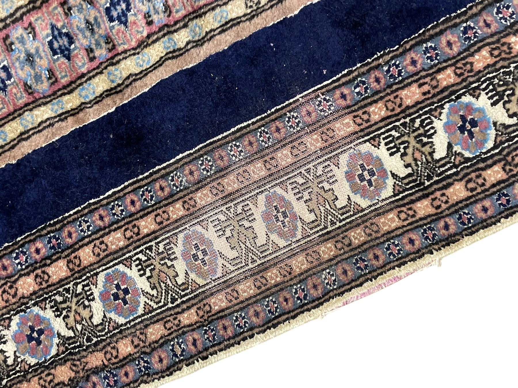 Indo-Persian indigo ground rug, the field depicting a rug with floral medallion and spandrels, enclosed within multiple floral pattern border bands