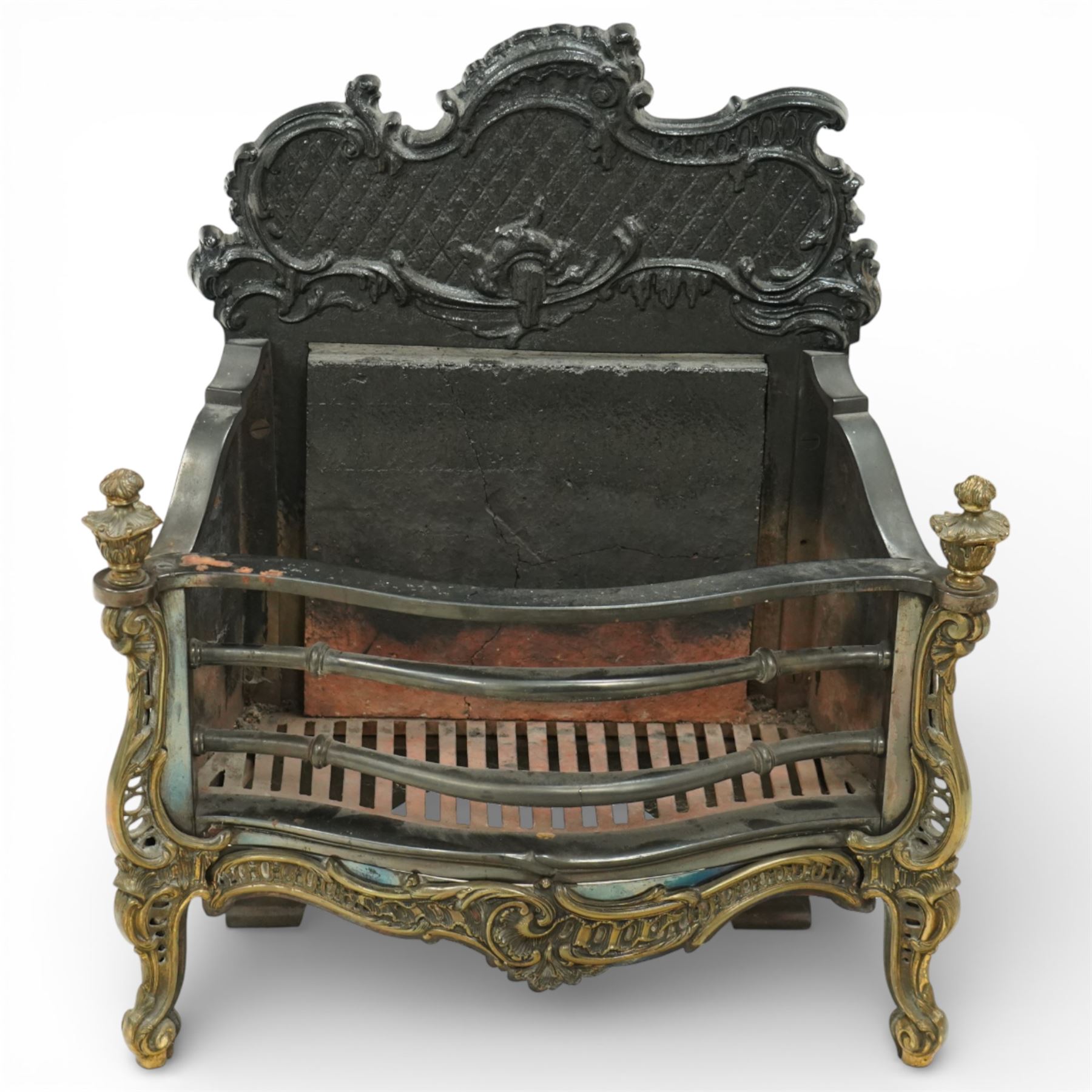 20th century Rococo style fire basket, cast iron back plate with pierced and scroll moulded cresting, steel fire bars and grate, ormolu mounted uprights with foliate scrollwork, on shaped feet