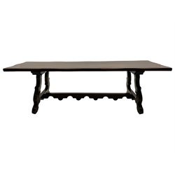 Large Spanish hardwood dining table, on shaped open ends supports joined by stretcher 
