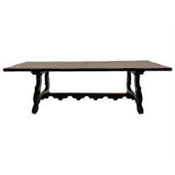 Large Spanish hardwood dining table, on shaped open ends supports joined by stretcher 
