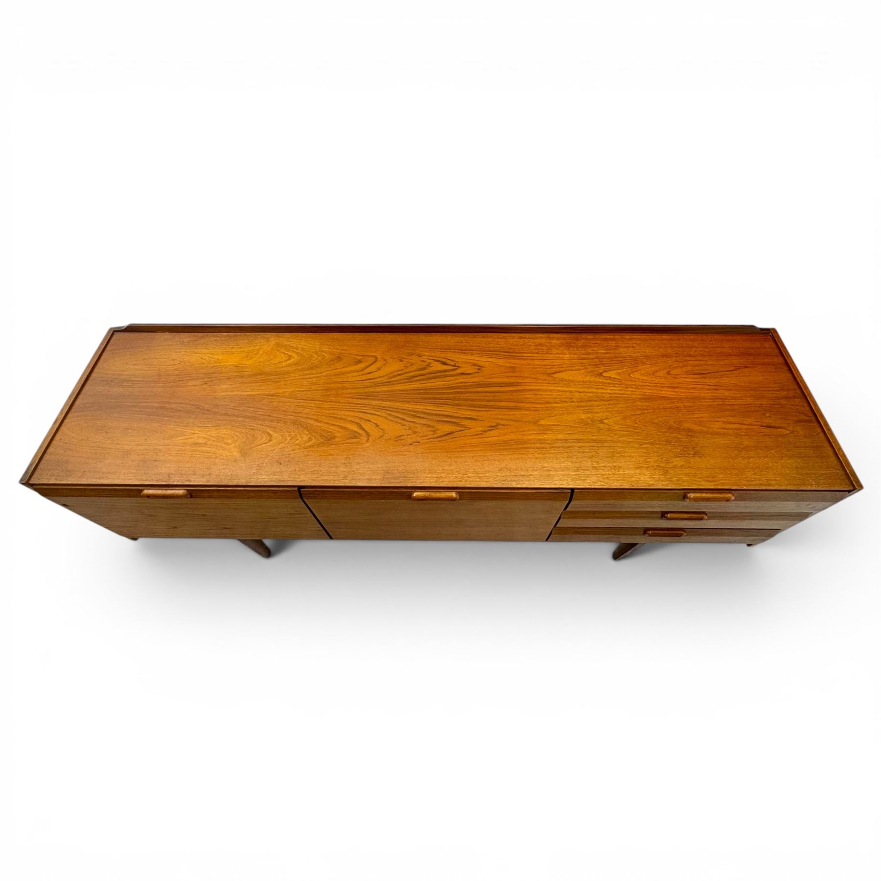 BCM (Bath Cabinet Makers) - mid-20th century teak sideboard, rectangular top with back gallery, left hand side fall front cupboard, centre cupboard opening to reveal a shelved interior, the right side with a bank of three drawers one fitted for cutlery, raised on inset tapering supports